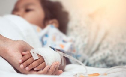 Sick child in a hospital bed with a drip 